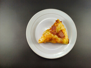 Cheesy and Meaty Pizza on Small White Plate Against Dark and Ash Abstract Background: Enjoy a Savory Delight with Melted Cheese and Flavorful Meat, Perfectly Presented for Your Culinary Pleasure