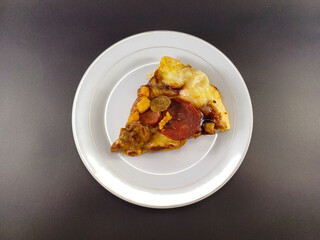 Cheesy and Meaty Pizza on Small White Plate Against Dark and Ash Abstract Background: Enjoy a Savory Delight with Melted Cheese and Flavorful Meat, Perfectly Presented for Your Culinary Pleasure