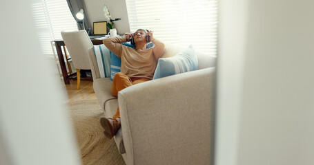 Woman, headphones and relax on couch for music, streaming and audio book or podcast in home. Radio,...