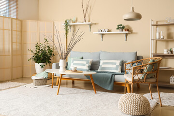 Interior of living room with sofa and willow branches in vases