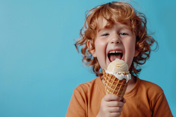 Cheerful happy kid eating ice cream in waffle cone on blue background with copy space. Suitable for summer and leisure-related content.