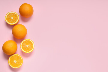 Composition with ripe tasty oranges on pink background