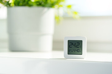 White Digital Thermometer Displaying Room Temperature and Humidity