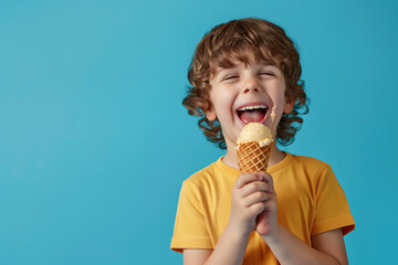 Cheerful happy kid eating ice cream in waffle cone on blue background with copy space. Ideal for advertising, summer promotions, and lifestyle publications.