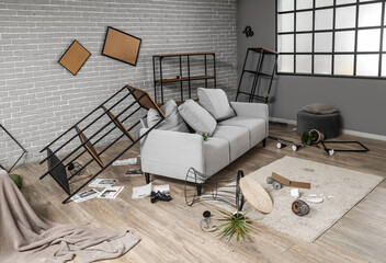 Interior of messy living room with sofa and shelf units