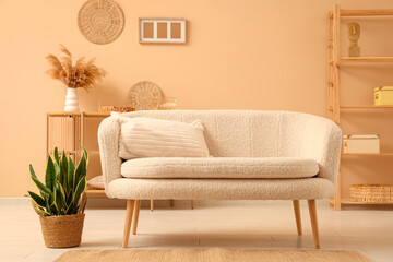 Comfortable sofa and wooden shelving unit with decor in interior of living room