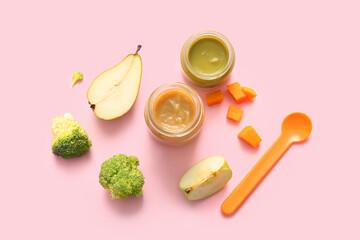 Jars of healthy baby food, ingredients and spoon on pink background