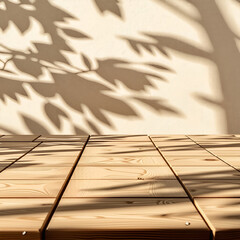 Empty wood table top on beige wall texture with tree leaves shadow background