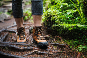 Hiking boots on trekking trail in forest. Outdoor leather shoes