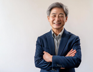 黒いスーツ姿で笑顔で腕組みをする60代の男性実業家 経営者