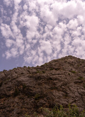 A mountain with a cloudy sky in the background