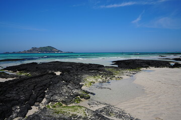 clear rock beach and far island