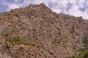 A rocky mountain with green vegetation on it
