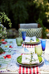 A bright, festive outdoor garden setting in a yellow and red palette with wildflowers, berries and watermelon