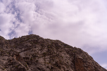 A mountain with a cloudy sky in the background