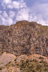 A mountain with a cloudy sky in the background