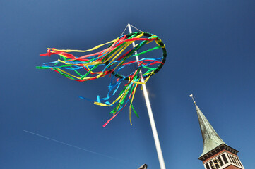 Maibaum #Tannenkranz mit bunten Bändern ein alter Brauch zu Volksfesten im Frühjahr vor blauen...