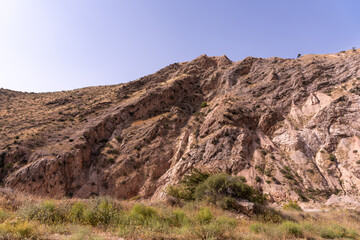 A rocky mountain with a few trees on it