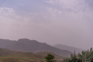 Obraz premium A mountain range with a cloudy sky in the background
