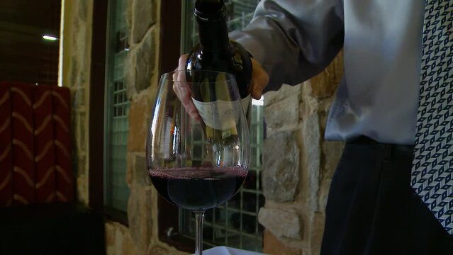 pouring red wine into glass