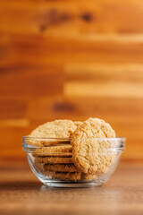 Tasty oatmeal cookies  in bowl on wooden table.