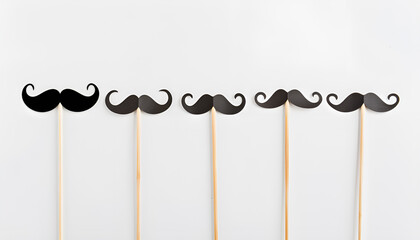 Set of different paper mustaches on wooden sticks against white background