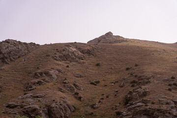 A rocky hillside with a large rock in the middle