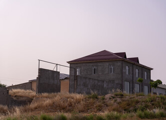Fototapeta premium A large house with a red roof sits on a hill
