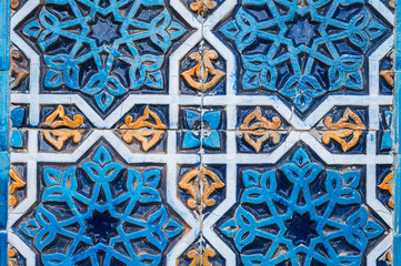 ancient ceramic tile with a traditional Arabic pattern Uzbek ornament decorates the wall of islamic...