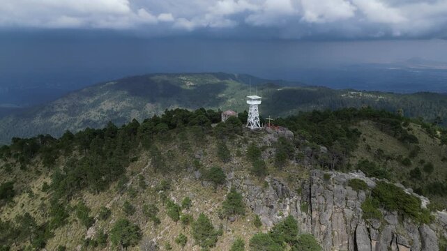 Aerial pulls out from lookout tower next to old hermitage on mtn top