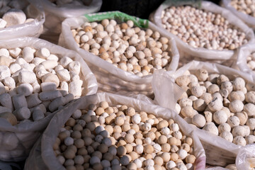 A pile of white and tan colored balls are in a white bag