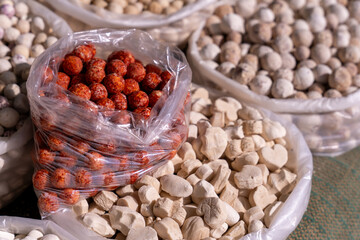 A bag of red balls sits next to a bag of white balls