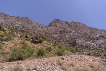 A mountain range with a clear blue sky in the background