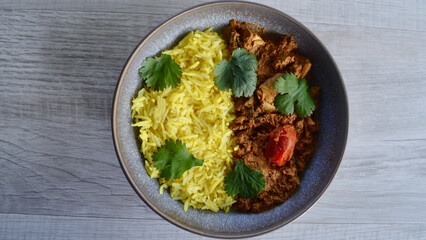 Ashoka chicken with saffron rice and coriander leaves.