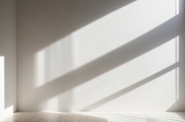 Sunlight casting shadows through window on white wall and wooden floor
