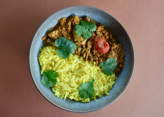Ashoka chicken with saffron rice and coriander leaves.