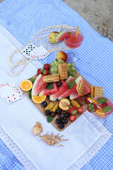 summer picnic on the seashore. board games on a picnic blanket. dominoes, lotto and cards. fruits and berries for a snack