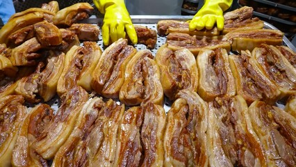 Cooked pork ribs are meticulously arranged on a perforated surface, signifying the culinary process in an industrial kitchen.