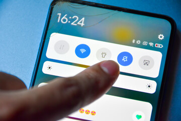 Finger pressing to turn off notification mode on Android mobile phone display screen and...