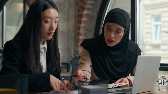 Businesswomen Islamic Muslim girl businesswoman mentor leader hijab help Asian Chinese Japanese female intern woman paperwork documents corporate rules discuss multiracial office women business girls