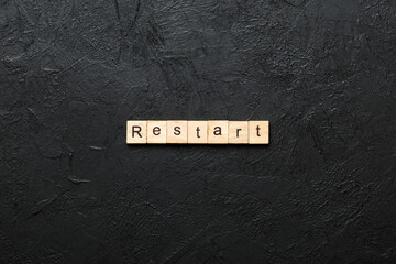 restart word written on wood block. restart text on table, concept