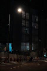 Night photography on a Hong Kong street photo with construction site at night, and water-filled...