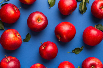 Many red apples on colored background, top view. Autumn pattern with fresh apple above view