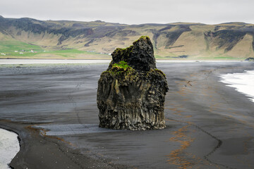 Iconic basalt column on black sand beach Reynisfjara on south iceland near vik i myrdal in moody...