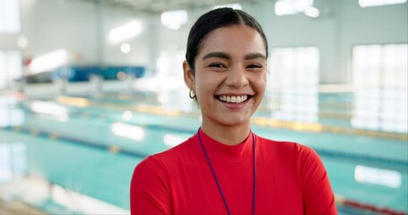 Girl, swimming coach and happy in indoor aquatic center, arms crossed and confident for lesson. Female person, trainer and instructor as teacher with smile, whistle and ready for session by pool