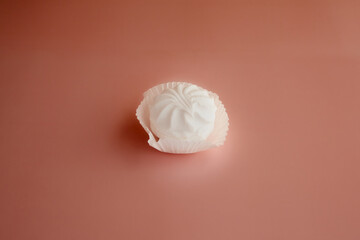 White marshmallows on a pink background, white marshmallow in a paper tartlet