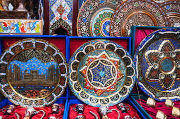 Uzbek handmade metal and wooden plates hand-painted in a souvenir market of Uzbekistan in Tashkent
