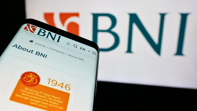 Stuttgart, Germany - 06-24-2024: Smartphone with webpage of Indonesian financial company Bank Negara Indonesia (BNI) in front of logo. Focus on top-left of phone display.