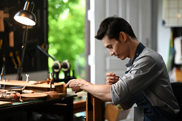Focused craftsman meticulously stitching leather with a needle and thread. Leather craft concept