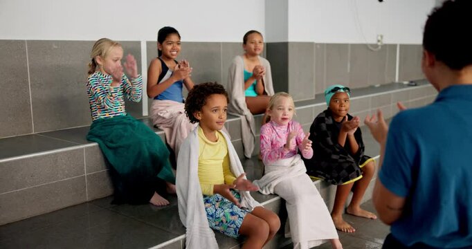 Teaching, kids and lessons for swimming, sport and clapping learning, bench and listen to teacher. Swimmer, boys and girls in group for fun in middle school, explanation and smile for rules of pool